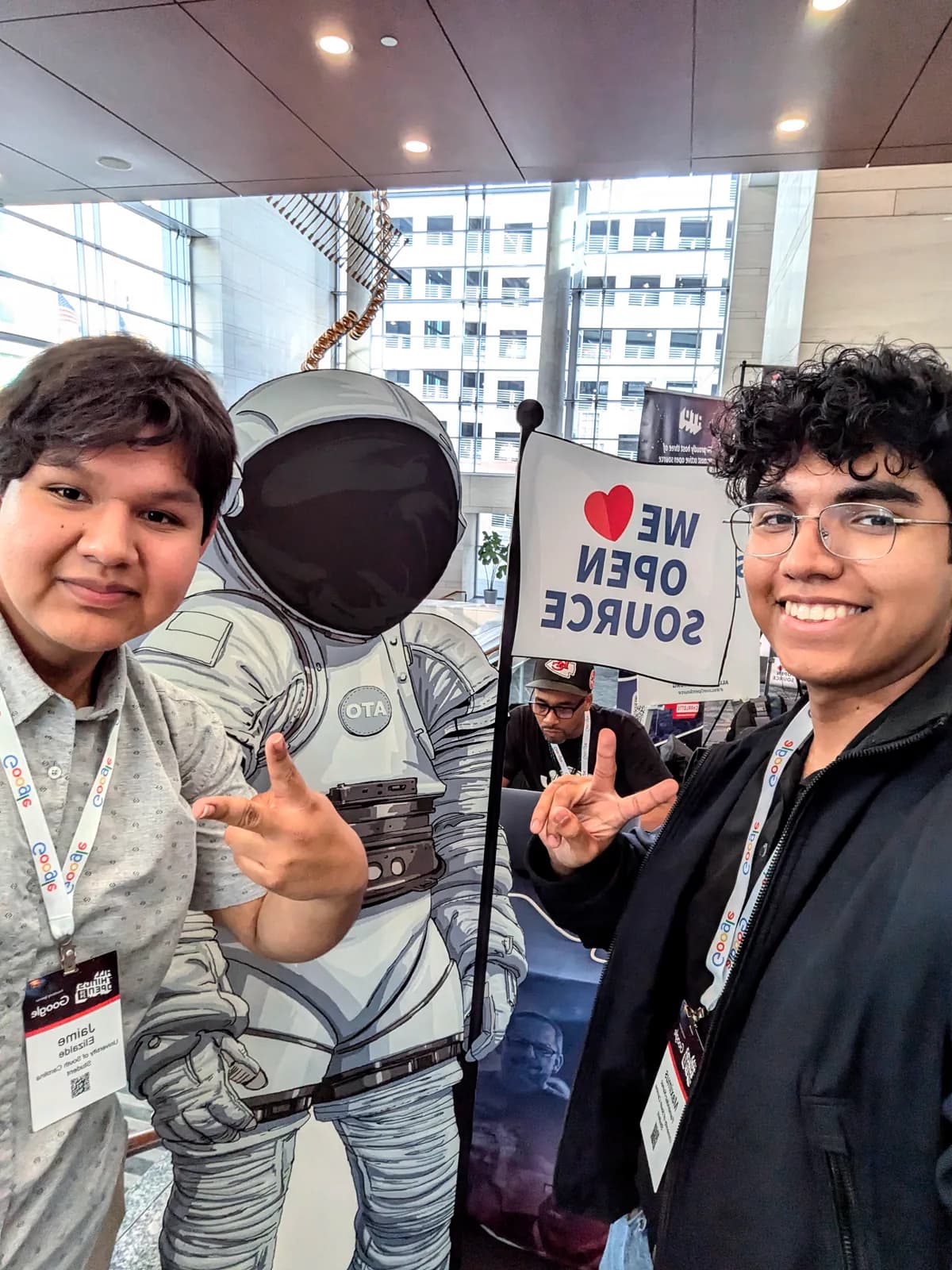 Maximus Fernandez, right, and a friend posing beside an astronaut cutout at All Things Open