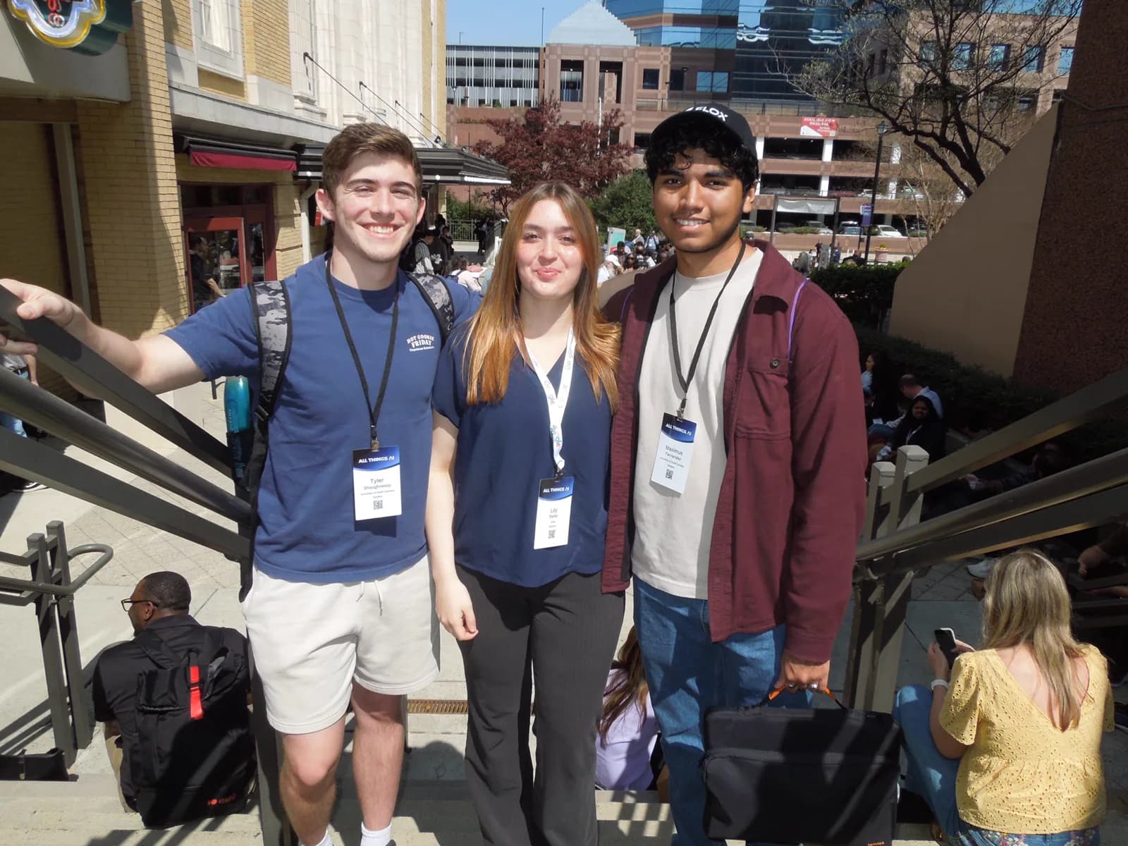 Maximus Fernandez, right, with two friends outside the All Things AI conference