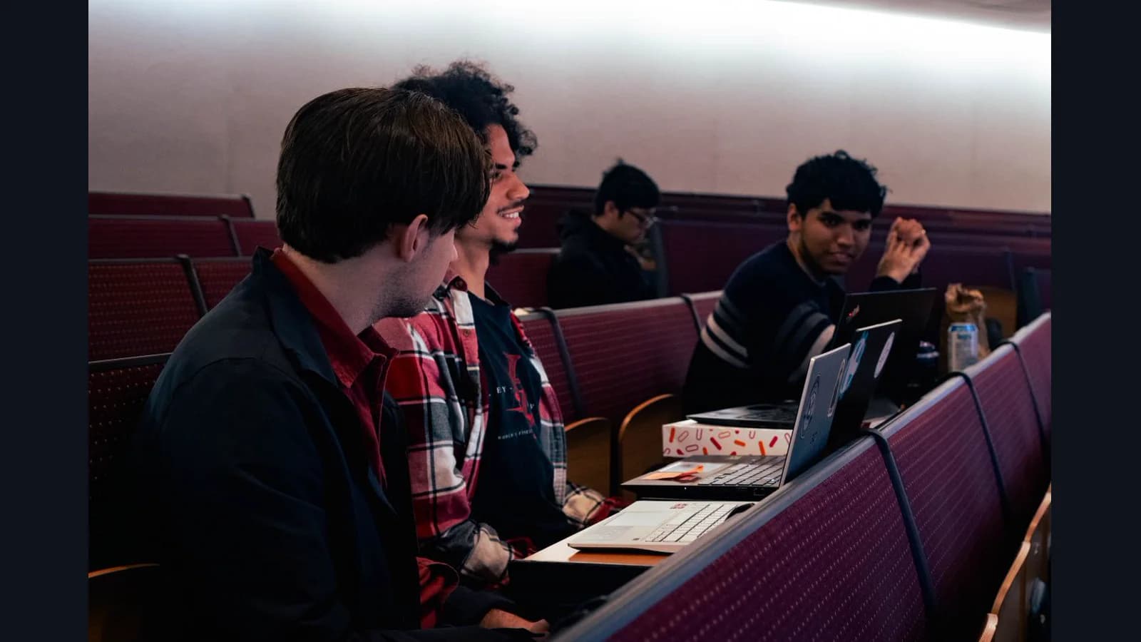 Lingua Franca teammates working together with laptops during the hackathon